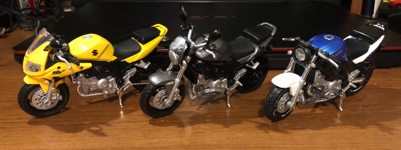 Both customs began life as the yellow SV650SK5+ seen far left in this family picture. Both of us have the same belly pan fairing in real life, and I created the 1:18 versions from balsa wood.